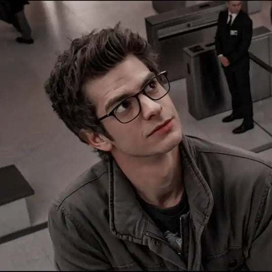 Man wearing glasses and a jacket in an indoor setting
